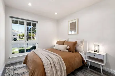 a white bedroom with a bed and a window at GOODE HOMES Cozy 4 Bedroom Home with Jacuzzi in Santa Clarita