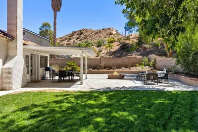 a patio with a table and chairs in a yard at GOODE HOMES Cozy 4 Bedroom Home with Jacuzzi in Santa Clarita