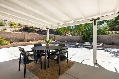 a patio with a table and chairs under a pergola at GOODE HOMES Cozy 4 Bedroom Home with Jacuzzi in Santa Clarita