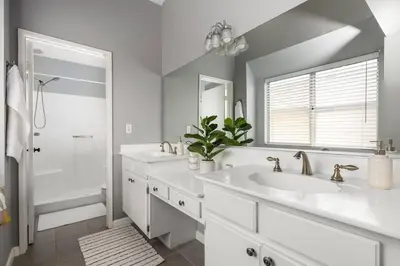 a white bathroom with two sinks and a shower at GOODE HOMES Luxury Modern Home with Jacuzzi in Santa Clarita