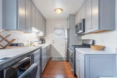 a kitchen with white cabinets and a counter top at Sawtelle Serenity- Modern Comfort in Los Angeles