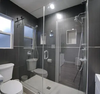 a bathroom with a glass shower with a toilet and a sink at Modern LA Home - King Bed, Outdoor Living, Firepit in Los Angeles