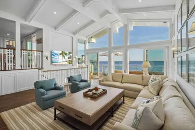 a living room with a couch and chairs and the ocean at The Getaway Oceanfront Villa in Malibu by Stay Awhile in Malibu