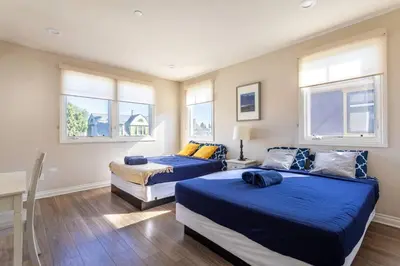 a bedroom with two beds and windows in it at Getaway 4BR Home in the Heart of LA in Los Angeles