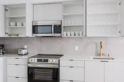 a kitchen with white cabinets and a stove and microwave at Blueground Brentwood pool gym near metro LAX-1285 in Los Angeles