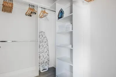 a white walk in closet with white shelves at Blueground Brentwood pool gym near metro LAX-1285 in Los Angeles