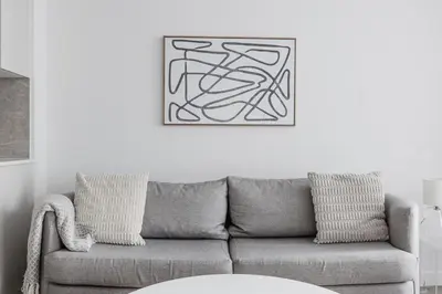 a living room with a gray couch and a picture at Blueground Brentwood pool gym near metro LAX-1285 in Los Angeles