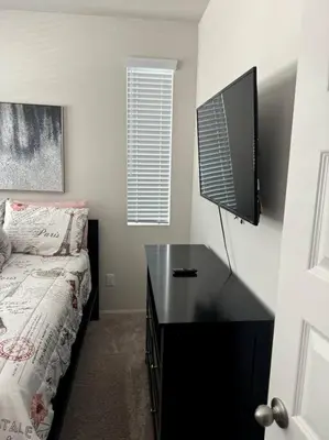 a bedroom with a desk with a tv and a bed at Cozy Home 20 Mins from DTLA in West Covina