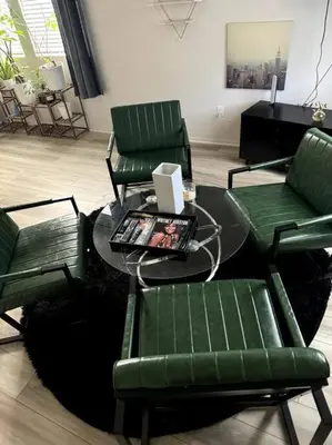 a living room with green chairs and a table with a laptop at Cozy Home 20 Mins from DTLA in West Covina