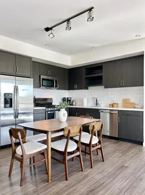 a large kitchen with a wooden table and chairs at West Hollywood Gem 2-Bedroom Apartment in Los Angeles