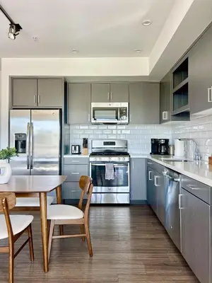 a kitchen with stainless steel appliances and a table and chairs at West Hollywood Gem 2-Bedroom Apartment in Los Angeles