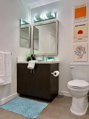 a bathroom with a sink and a toilet and a mirror at West Hollywood Gem 2-Bedroom Apartment in Los Angeles
