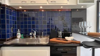a kitchen with a sink and a blue tiled wall at Coastal Retreat Steps from the Santa Monica Beach in Los Angeles