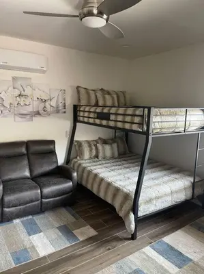 a bedroom with a bunk bed and a couch at Elegant private studio with private entrance and pool access in San Gabriel