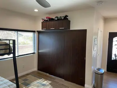 a room with a large wooden door in a bedroom at Elegant private studio with private entrance and pool access in San Gabriel