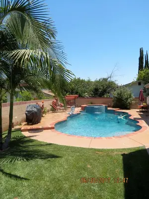 a swimming pool in a yard with a palm tree at Elegant private studio with private entrance and pool access in San Gabriel