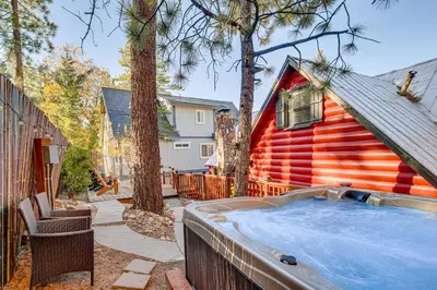 a backyard with a hot tub next to a house at Hot Tub, Grill and Fire Pit Cabin in Big Bear Lake in Big Bear Lake