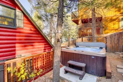 a hot tub sitting next to a red house at Hot Tub, Grill and Fire Pit Cabin in Big Bear Lake in Big Bear Lake