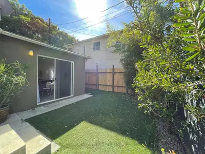 a backyard of a house with a yard with a fence at Pristine 1BD 1BA Bungalow With Hot Tub in Los Angeles