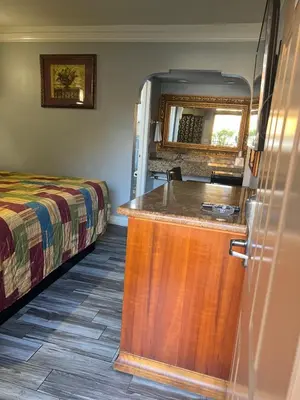 a bedroom with a bed and a kitchen with a counter at Amber Motel in Inglewood