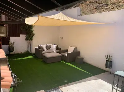 a patio with two couches on a green lawn at Stunning Mediterranean Mansion in Laurel Canyon in Los Angeles