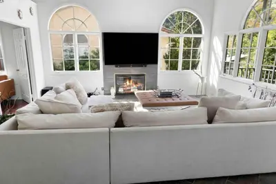 a living room with a white couch and a fireplace at Stunning Mediterranean Mansion in Laurel Canyon in Los Angeles