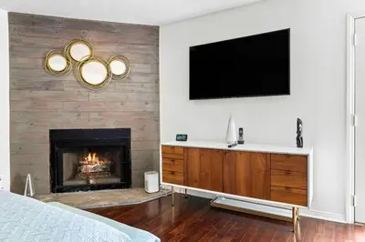 a bedroom with a fireplace and a television on a wall at Stunning Mediterranean Mansion in Laurel Canyon in Los Angeles