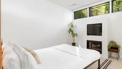 a white living room with a white couch and a tv at Kings Road West Hollywood Luxury Pool Views Firepit Modern Design in Los Angeles