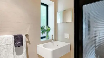 a bathroom with a white sink and a mirror at Kings Road West Hollywood Luxury Pool Views Firepit Modern Design in Los Angeles