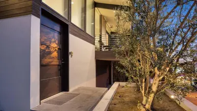 a door to a house with a tree next to it at Kings Road West Hollywood Luxury Pool Views Firepit Modern Design in Los Angeles