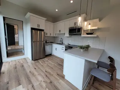 a kitchen with white cabinets and a white counter top at Sumac in Los Angeles