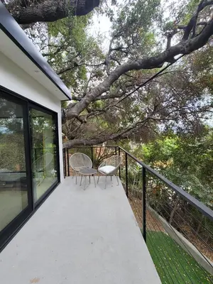 a balcony with two chairs and a tree at Sumac in Los Angeles