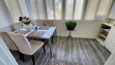 a dining room with a table and chairs and windows at LAX House Near SoFi Stadium, Intuit Dome, YouTube Theater, The Kia Forum, Beaches in Inglewood
