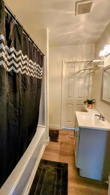 a bathroom with a black shower curtain and a sink at LAX House Near SoFi Stadium, Intuit Dome, YouTube Theater, The Kia Forum, Beaches in Inglewood