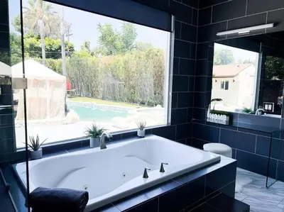 a large tub in a bathroom with a large window at Luxury Oasis in Central Encino w Pool & Spa Topeka in Los Angeles