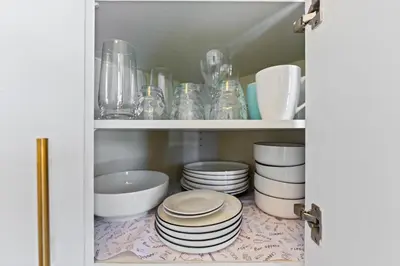 a cupboard filled with plates and bowls and dishes at Ocean View Studio Near Convention Center and Beach in Long Beach