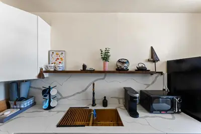 a living room with a tv and a counter with a microwave at Ocean View Studio Near Convention Center and Beach in Long Beach