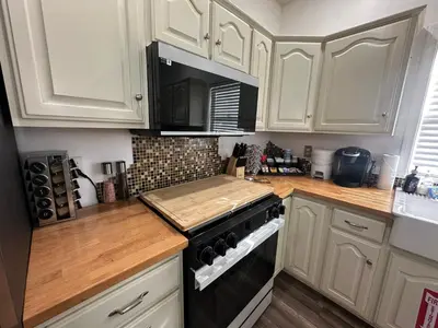 a kitchen with white cabinets and a stove top oven at Enjoy Privacy - Pine Mountain - Spacious Home in Pine Mountain Club
