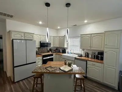 a kitchen with white cabinets and a table with chairs at Enjoy Privacy - Pine Mountain - Spacious Home in Pine Mountain Club