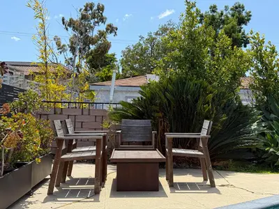 two wooden chairs and a bench on a patio at Charming Studio Oasis with Pool Near SoFi - MKLAD4 in Los Angeles
