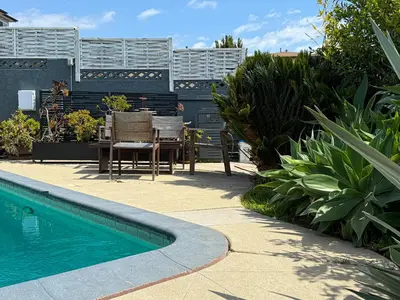a patio with a table and chairs next to a swimming pool at Charming Studio Oasis with Pool Near SoFi - MKLAD4 in Los Angeles