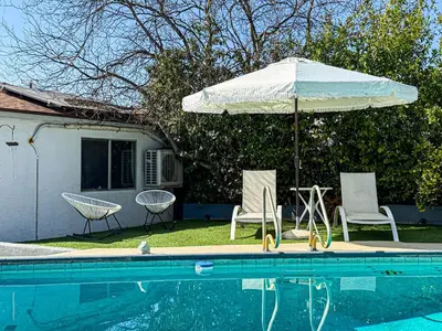 a pool with an umbrella and two chairs and a table with an umbrella at Charming Poolside ADU Near SoFi Stadium - MK3LAD in Los Angeles