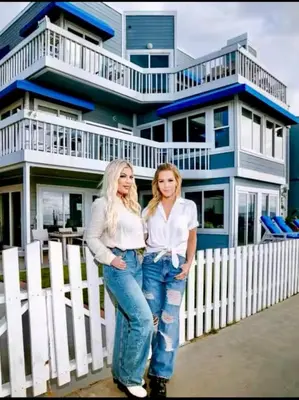 two women standing in front of a blue and white house at 90210 Beach House Top Unit in Hermosa Beach