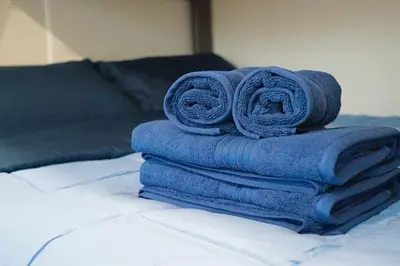a pile of towels sitting on top of a bed at Beautiful Renovated Cozy Forest Home with Hot Tub in Crestline in Crestline