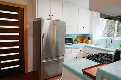 a kitchen with a stainless steel refrigerator and white cabinets at Beautiful Renovated Cozy Forest Home with Hot Tub in Crestline in Crestline