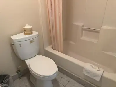 a bathroom with a toilet with a roll of toilet paper on it at Best Star Inn - Montebello, Los Angeles in Montebello