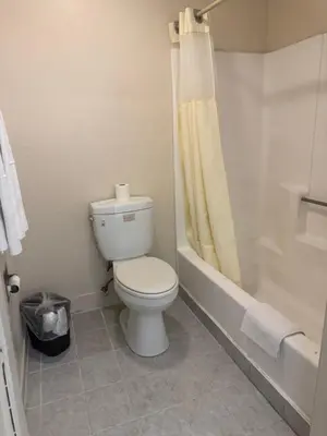 a white bathroom with a toilet and a shower at Best Star Inn - Montebello, Los Angeles in Montebello