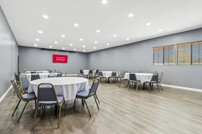 a conference room with tables and chairs in it at HomeTowne Studios by Red Roof Ridgecrest in Ridgecrest