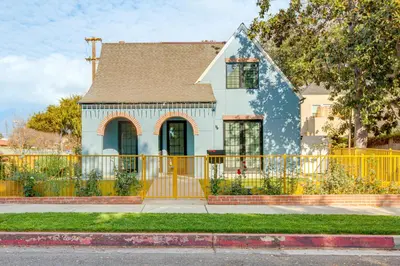 a house with a yellow fence in front of it at 1 Mi to Dtwn Pasadena! Newly Built Home in Pasadena