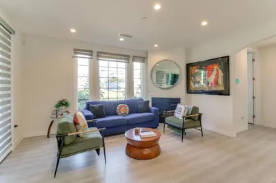 a living room with a blue couch and two chairs at 1 Mi to Dtwn Pasadena! Newly Built Home in Pasadena